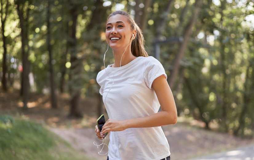 Vrouw die vrolijk hardloopt in het voorjaar. Zo kun jij ook meer energie krijgen.