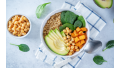 Een buddha bowl met avocado, rijst, zoete aardappel, spinazie en kikkererwten.