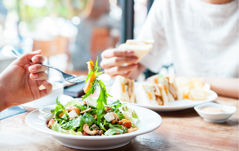 Een persoon eet langzaam een gezonde salade om zich energieker te voelen.