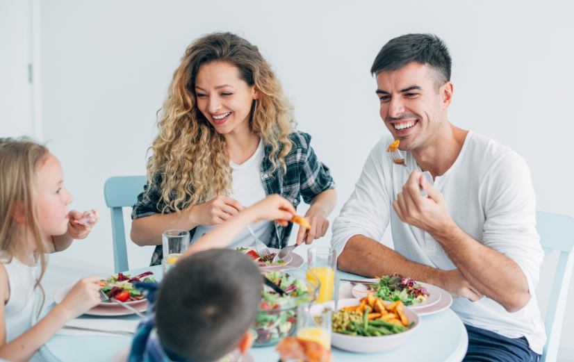 Familie met twee kinderen is gezellig en gezond aan het lunchen zonder brood.