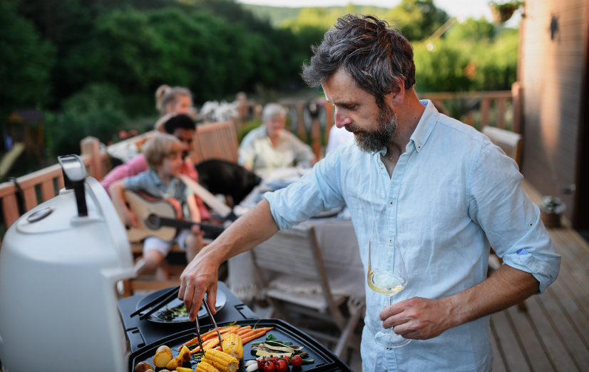 Man maakt deze gezonde BBQ-recepten en gaart groenten op de BBQ voor zijn familie. 