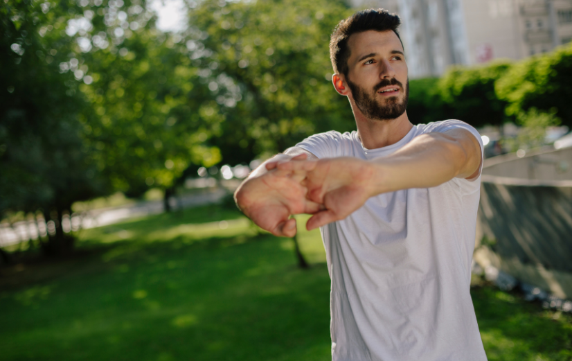 Man is aan het stretchen in het park en denkt aan alle leukste sporten voor buiten