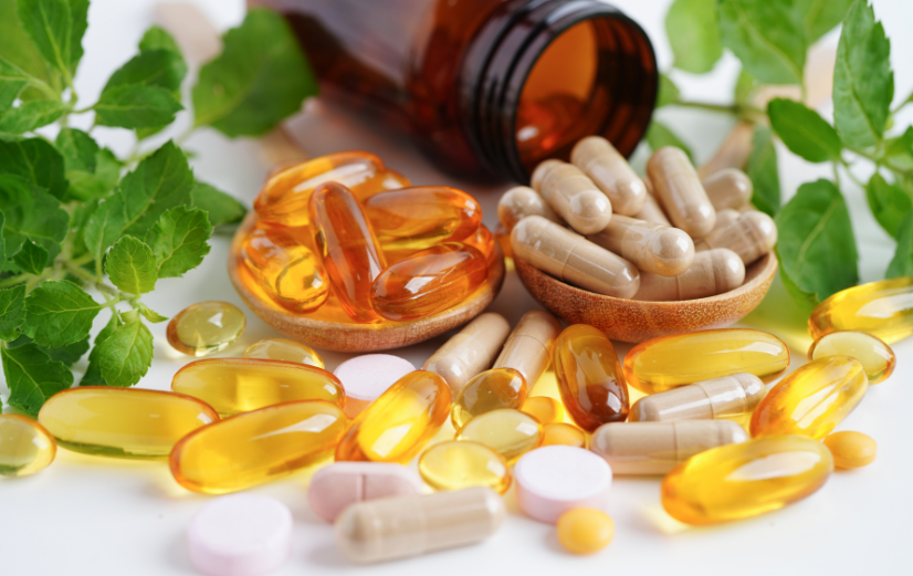 Verschillende vitamines en mineralen op een tafel die je met onze rekentool handig omrekent vanuit ug en mcg naar mg en ie.