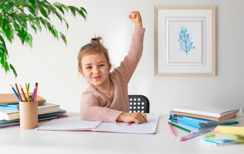 Meisje zit aan bureau en is enthousiast om het nieuwe schooljaar te beginnen.