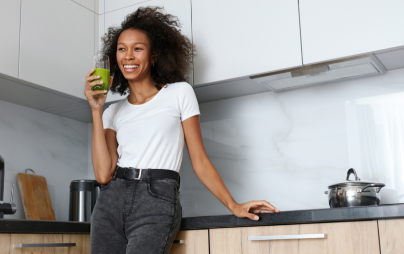 Vrouw drinkt detox-smoothie in de keuken wat goed is voor je lever